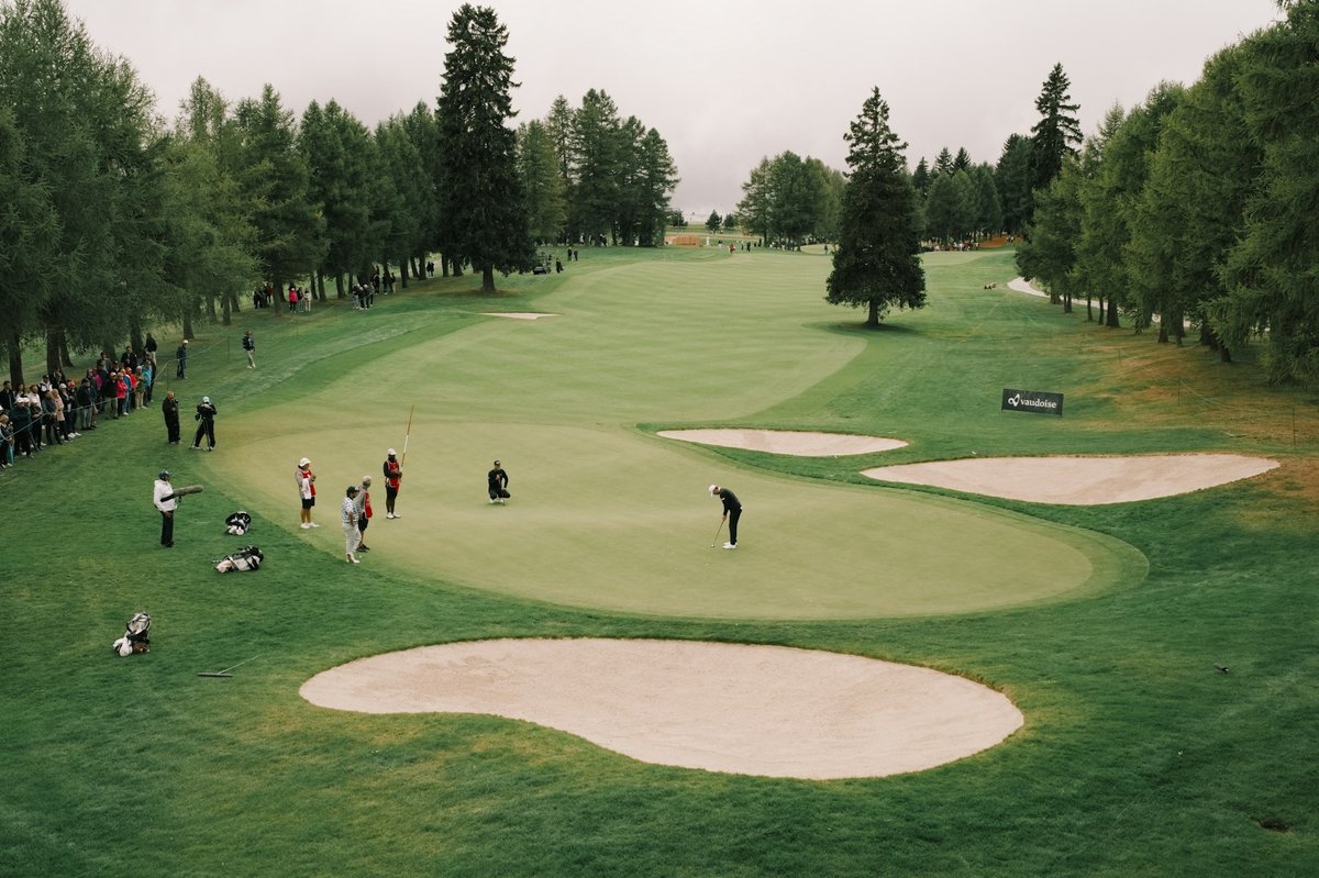 Green entouré de bunkers de sable, vu d'en haut, quelques joueurs